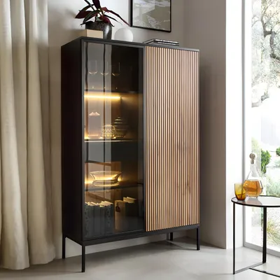 Produktbild von Vitrine mit LED-Beleuchtung, moderne Glasvitrine mit Schublade, Vitrinenschrank aus MDF mit Glasfront und Holzfüßen in Wotan-Eiche Schwarz
