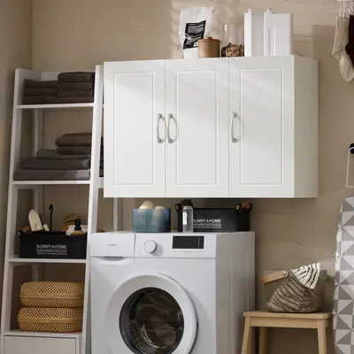A laundry room scene with a washing machine, wall cabinet, and shelving unit.