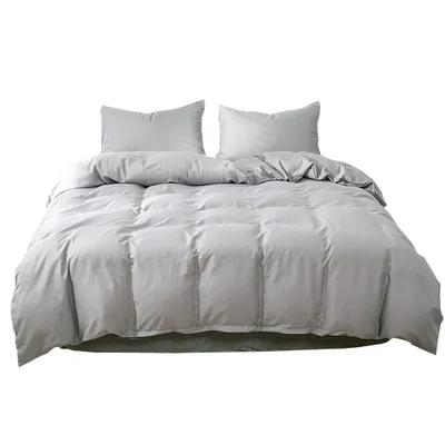 A light gray duvet cover and two pillowcases are neatly arranged on a bed. The bedding is shown from the front, with the duvet cover laid out flat and the pillowcases propped up behind it.