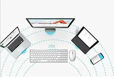 A desk setup with a monitor, laptop, tablet, keyboard, mouse, and smartphone, connected by wireless signals.