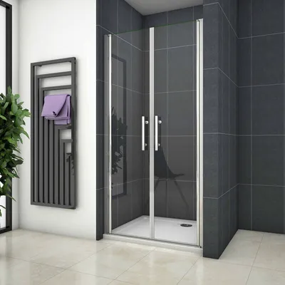 A modern bathroom with a shower enclosure, towel rack, and plant.