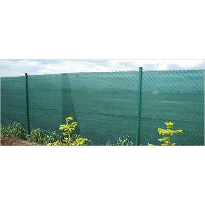A green privacy screen fence with metal posts, set against a cloudy sky and a field.