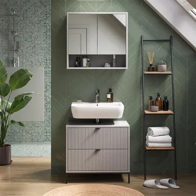 A modern bathroom with green tiled walls, a sink, vanity, and shelving unit.
