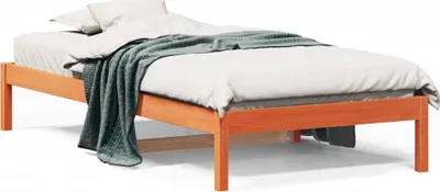 A wooden bed frame with bedding and a blanket.