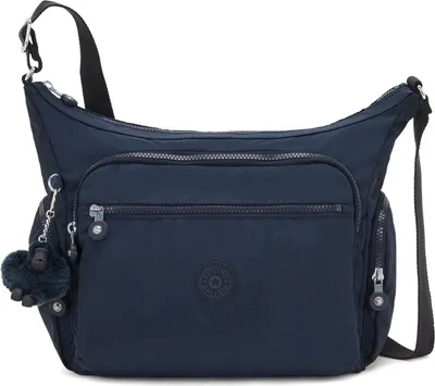 A navy blue Kipling crossbody bag with a furry monkey charm.