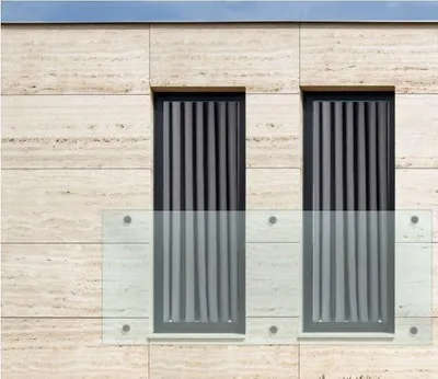 A modern building facade with two French balconies and travertine cladding.