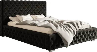 A black upholstered bed with a tufted headboard and footboard, shown with bedding.