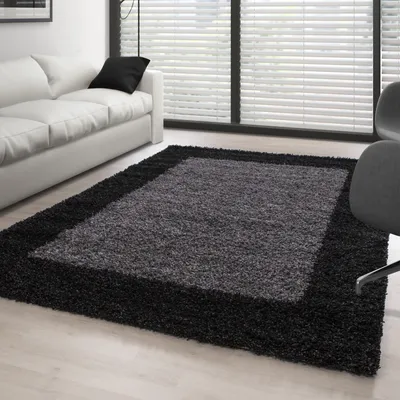 A modern living room with a white sofa and a shaggy rug.