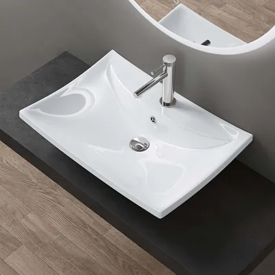 A white ceramic sink with a chrome faucet is shown on a dark countertop, with wooden flooring visible below.