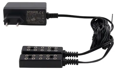 Auf dem Bild ist ein schwarzer Beleuchtungstrafo mit einer 10er-Steckleiste zu sehen der über ein langes Kabel mit dem Trafo verbunden ist und für die Stromversorgung von mehreren Geräten gleichzeitig genutzt werden kann