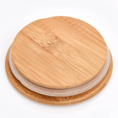 A close-up, top-down view of a bamboo lid with a clear silicone seal, placed on a white surface.