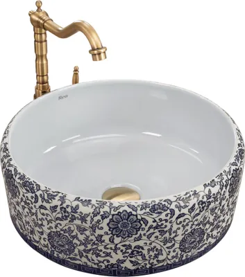 A white ceramic sink with a blue floral pattern and a gold faucet.