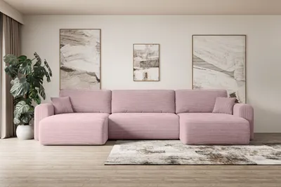 A pink sectional sofa is arranged in a living room setting with artwork on the wall and a plant.