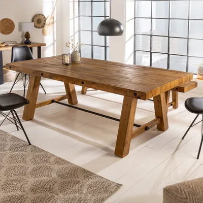 A dining room scene with a large wooden table and chairs.