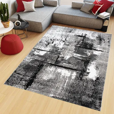 A modern living room scene featuring a sectional sofa, a rug, and decorative items.