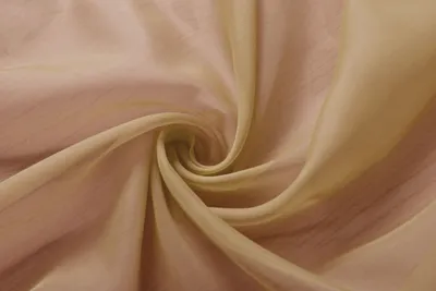 A close-up swirl of sheer, light-colored fabric, likely a curtain or sheer textile.