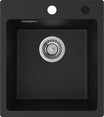 A top-down view of a black granite kitchen sink with a silver drain.