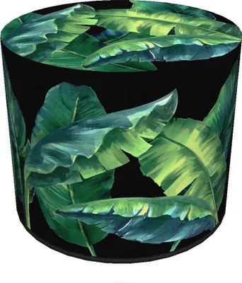 A cylindrical pouffe with a tropical leaf print on a black background.