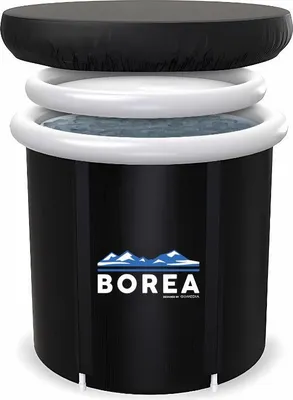 A black inflatable tub with a white rim, filled with water, and a black cover on top. The tub has a logo with mountains and the word 'BOREA' on it.