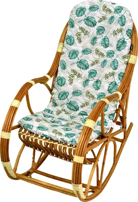 A rattan rocking chair with a cushion featuring a tropical leaf pattern, presented against a white background.