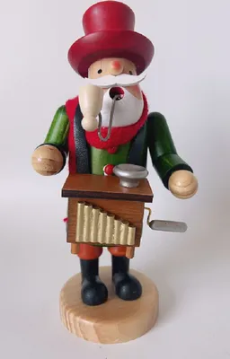Räuchermännchen Orgelspieler mit einem roten Zylinder, einem grünen Mantel, einem roten Schal.