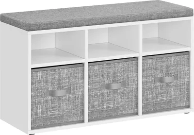 A white shoe bench with a gray upholstered top and three gray fabric storage bins with handles.