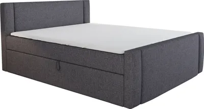 A dark gray upholstered boxspring bed with a white mattress is shown against a white background.