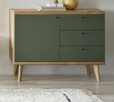 A modern sideboard with a green front and wooden accents, standing on angled wooden legs.