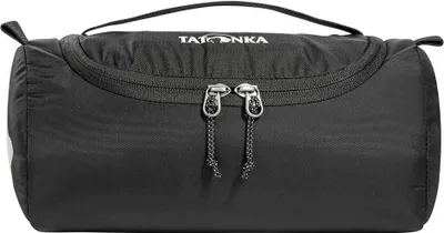 A black TATONKA toiletry bag is shown against a white background.