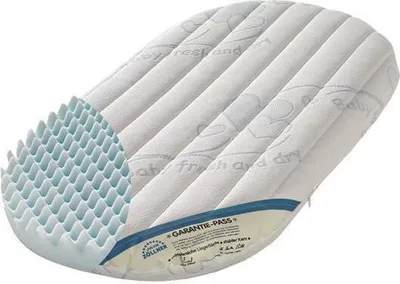 A cutaway view of a baby mattress, showing its layered construction and textured surface.