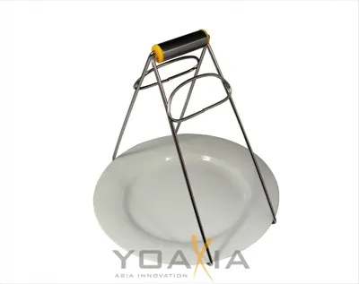 A kitchen clamp holding a white plate, presented on a white background.