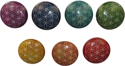 Seven round stones with the Flower of Life pattern carved into them, arranged in two rows.