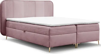 A pink upholstered boxspring bed with a white mattress and topper, shown from a slightly elevated side angle against a white background.