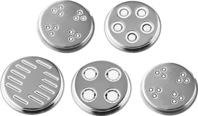A collection of five metal pasta discs with different hole patterns, arranged in a scattered formation on a white background.