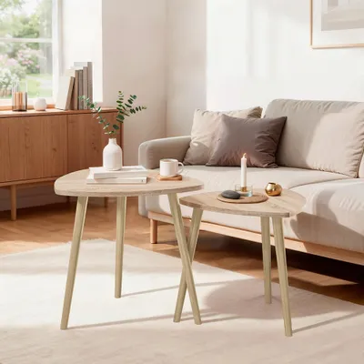 Two triangular coffee tables are placed in a living room setting, next to a sofa.