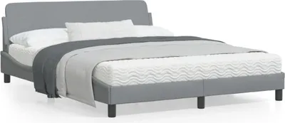A gray fabric bed frame with a headboard, shown with white and gray bedding, against a white background.