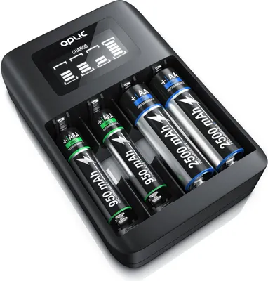 A black battery charger with four slots, each containing a rechargeable battery. The charger has a small digital display at the top showing charging status.