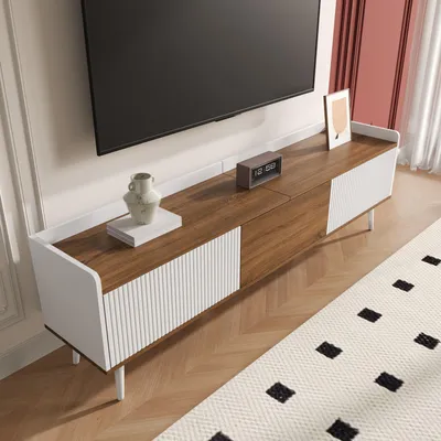 A modern TV stand with a TV mounted above it, in a well-lit room with a rug on the floor.