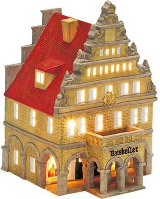 A miniature, illuminated model of a historic building with a red roof and yellow facade.