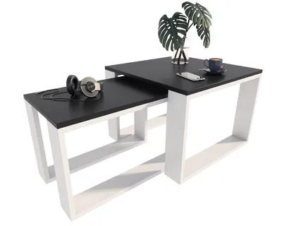 A set of two nesting coffee tables with black tops and white frames, displayed on a white background.