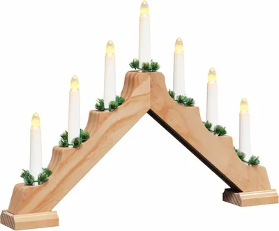 A wooden Christmas candle bridge with seven LED lights and green decorative sprigs, set against a white background.