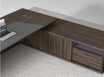 A modern L-shaped desk with a laptop on it, set against a light gray background.