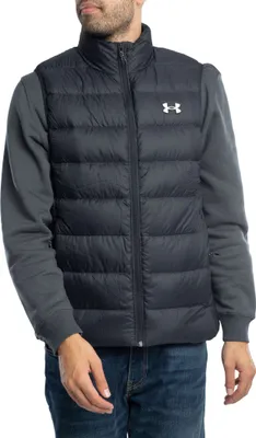 A man wearing a black puffer vest over a grey long-sleeved shirt and blue jeans.
