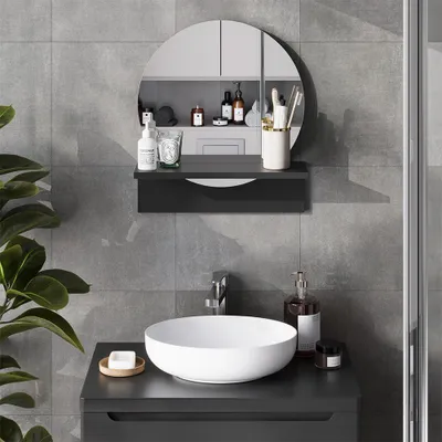 A modern bathroom vanity with a round sink and a circular mirror above it, featuring various toiletries and accessories.