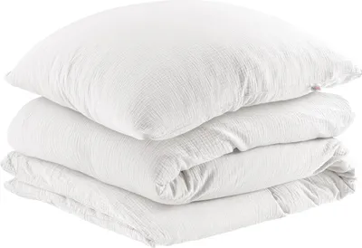 A stack of white bedding, including a pillow and a folded duvet.