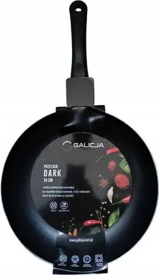 A black frying pan with a black handle, presented against a white background. A circular label is attached to the pan, displaying product information and branding.
