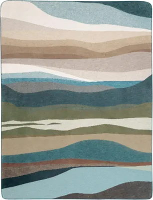 A flat lay of a blanket with a landscape-inspired abstract pattern.