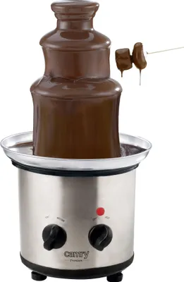 A chocolate fountain with melted chocolate flowing down its tiers, with two marshmallows on a skewer being dipped into the chocolate.
