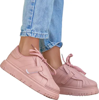 A person wearing jeans and pink sneakers.