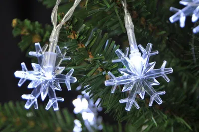 Close-up of snowflake-shaped LED lights on a Christmas tree.